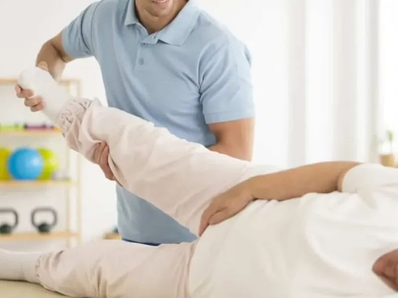 Physical therapist guiding a patient through a hip and knee mobility assessment