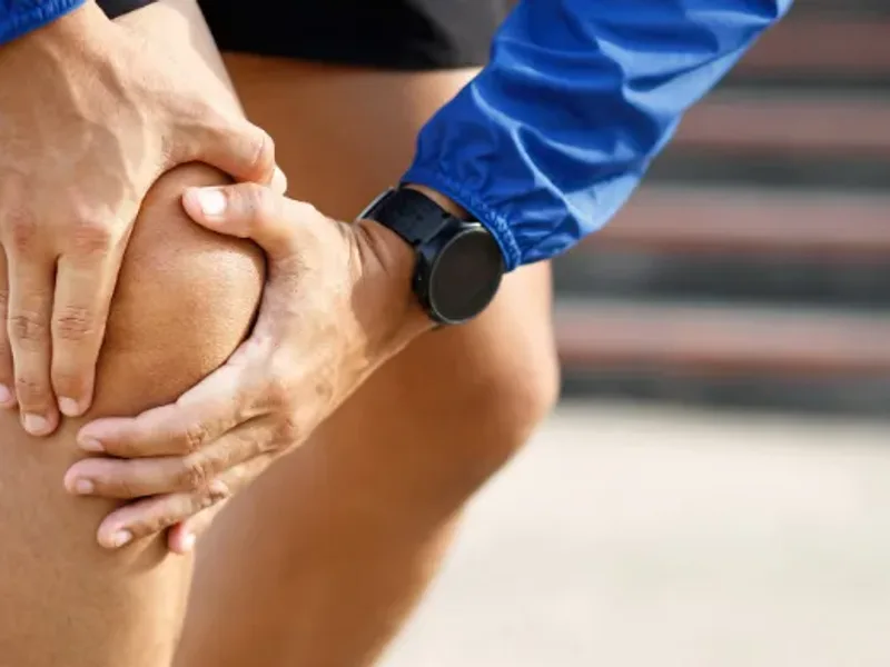 Person holding a sore knee joint after activity