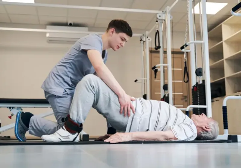 Patient performing a prescribed strengthening exercise with therapist coaching